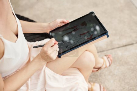 Téléchargez les photos : Gros plan de la jeune fille utilisant une tablette numérique pour dessiner à l'écran pendant ses vacances d'été - en image libre de droit