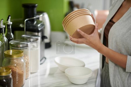Photo for Cropped image of woman taking biodegradable bowls for soup and porridge - Royalty Free Image