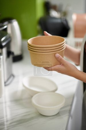 Téléchargez les photos : Mains de femme tenant pile de bols à soupe biodégradables - en image libre de droit