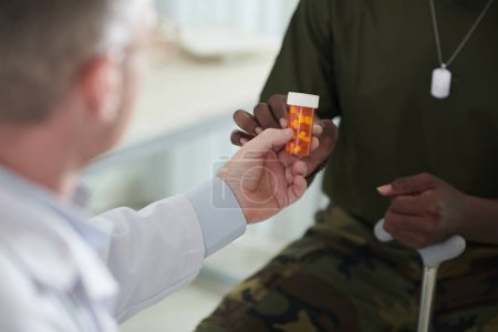 Photo for Closeup image of physician giving pills to military man - Royalty Free Image