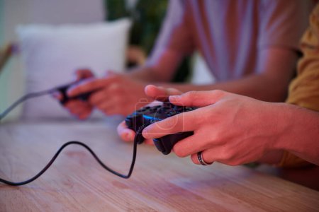 Photo for Hands of young man holding controller when playing video game - Royalty Free Image