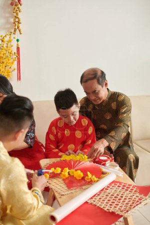 Foto de Familia vietnamita se reunió para hacer decoración de paredes para la celebración del Tet - Imagen libre de derechos