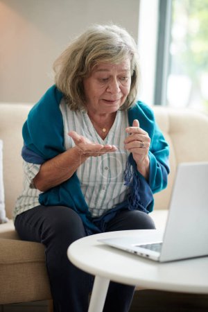 Foto de Mujer anciana que usa el servicio de telemedicina cuando llama por video a su médico - Imagen libre de derechos