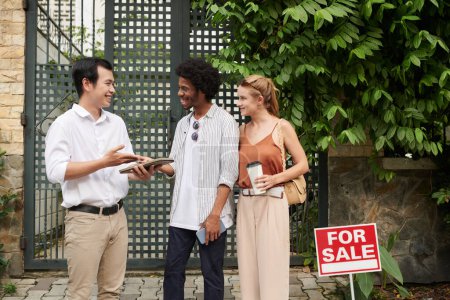 Téléchargez les photos : Agent immobilier positif discutant avec les clients de leurs préférences et attentes - en image libre de droit