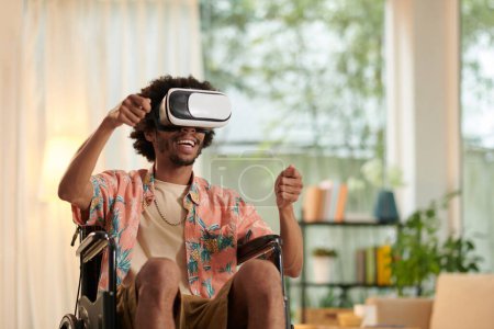 Téléchargez les photos : Homme excité avec handicap jouant jeu vidéo de course en vr casque - en image libre de droit