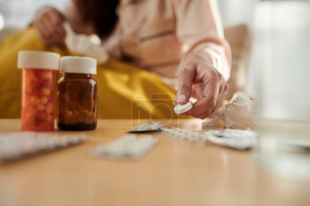 Photo for Sick woman taking huge aspirin tablet from bedside table, illness and recovery concept - Royalty Free Image