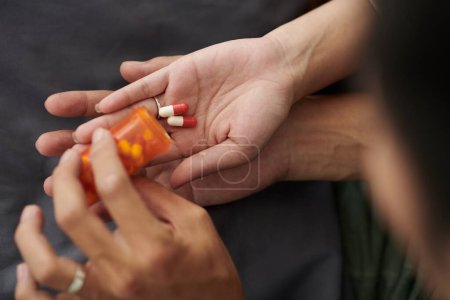 Téléchargez les photos : Mari aidant femme malade et fatiguée à prendre une dose quotidienne de pilules - en image libre de droit