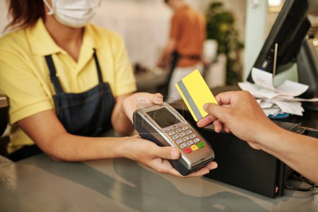 Téléchargez les photos : Client glissant la carte de crédit lors du paiement de la commande dans coffeeshop - en image libre de droit