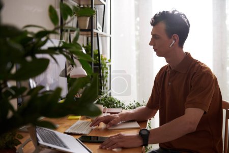 Téléchargez les photos : Développeur de logiciels parlant au chef d'équipe lors d'une réunion en ligne lorsque vous travaillez à domicile - en image libre de droit