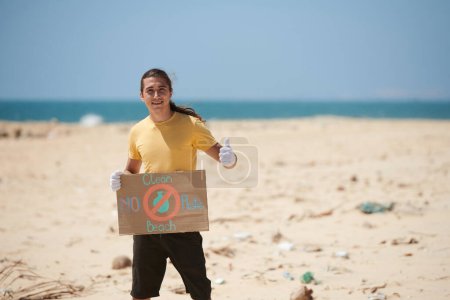 Téléchargez les photos : Un militant demande aux gens de nettoyer la plage sans utiliser de plastique - en image libre de droit