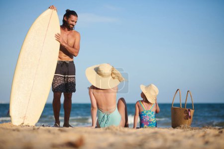 Téléchargez les photos : Fit surfer parler à sa famille de bronzage après avoir nagé dans l'océan - en image libre de droit