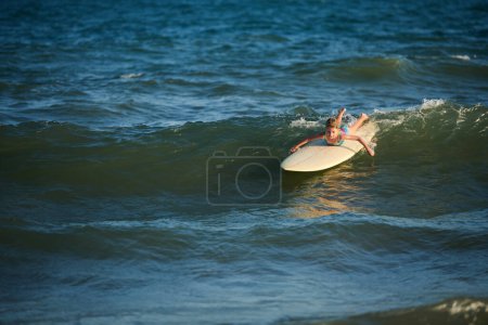 Téléchargez les photos : Preteen fille surf dans la mer, attraper les vagues et la natation - en image libre de droit