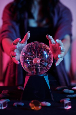 Téléchargez les photos : Image rapprochée d'une diseuse de bonne aventure regardant dans une boule de cristal et voyant la fortune - en image libre de droit