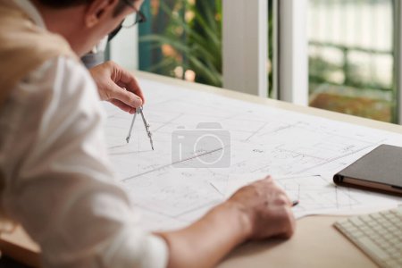 Téléchargez les photos : Ingénieur civil dessin avec boussole lors du travail sur le plan de construction - en image libre de droit