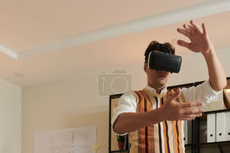 Téléchargez les photos : Architecte utilisant des lunettes VR lors de l'examen du bâtiment en réalité virtuelle - en image libre de droit