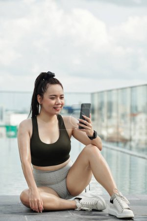 Photo for Smiling sportswoman taking selfie after working out outdoors - Royalty Free Image