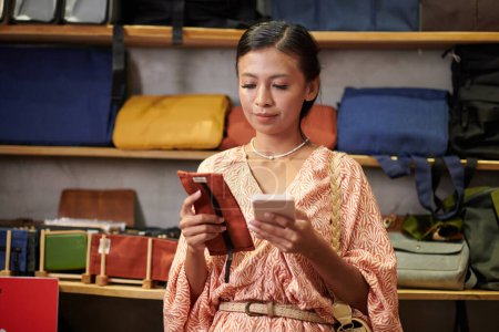 Téléchargez les photos : Jeune femme pensant qu'elle a besoin d'une nouvelle coque de smartphone textile - en image libre de droit