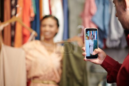 Photo for Young man taking photo of friend with dresses for her fashion blog - Royalty Free Image