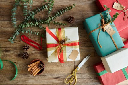 Téléchargez les photos : Arrière-plan avec des cadeaux de Noël enveloppés décorés de rubans colorés, cônes de pin et branches d'eucalyptus - en image libre de droit
