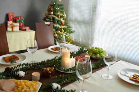 Foto de Mesa de cena de Navidad con varios aperitivos preparados para la celebración familiar - Imagen libre de derechos