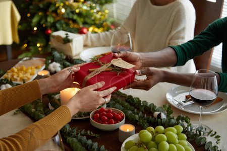 Téléchargez les photos : Amis échangeant des cadeaux à la fête de Noël à la maison - en image libre de droit