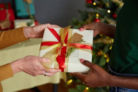Téléchargez les photos : Amis échangeant des cadeaux de Noël à la maison fête - en image libre de droit