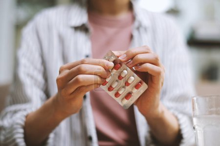 Téléchargez les photos : Image recadrée de la femme prenant des pilules et des suppléments le matin - en image libre de droit