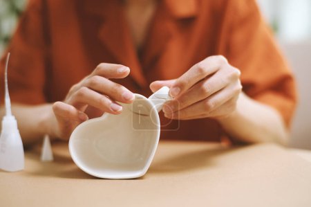 Téléchargez les photos : Mains de femme collant poignée à tasse de café en forme de coeur - en image libre de droit