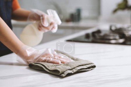 Téléchargez les photos : Image rapprochée d'une personne essuyant un comptoir de cuisine avec une serviette en coton - en image libre de droit