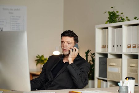 Foto de Retrato de empresario serio discutiendo informe en la pantalla de la computadora en el teléfono con compañero de trabajo - Imagen libre de derechos