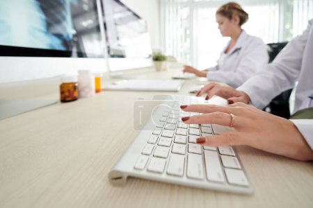 Téléchargez les photos : Mains de médecin femelle tapant sur le clavier de l'ordinateur - en image libre de droit