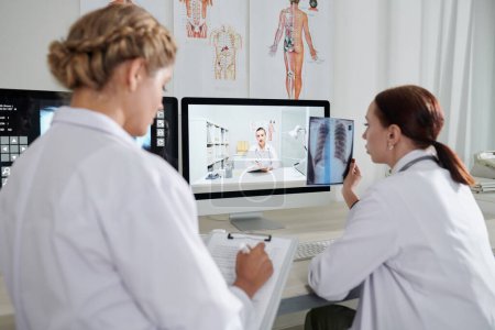 Téléchargez les photos : Groupe de travailleurs médicaux discutant de radiographie pulmonaire lors d'une réunion en ligne - en image libre de droit