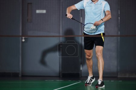 Photo for Cropped image of professional sportsman serving shuttlecock - Royalty Free Image
