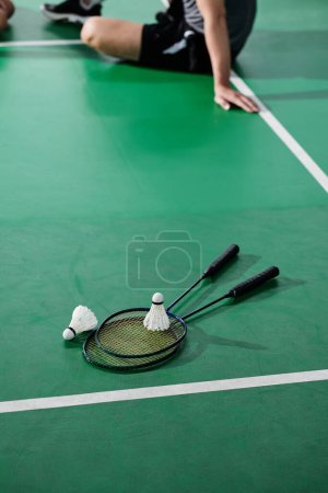 Téléchargez les photos : Deux raquettes de badminton et des navettes sur le sol de la cour - en image libre de droit