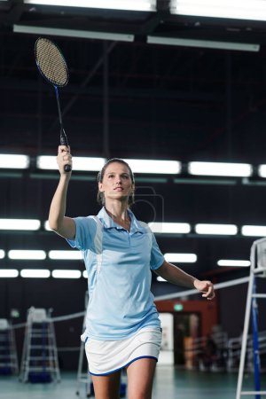 Téléchargez les photos : Jeune femme active jouissant de jouer au badminton sur le terrain - en image libre de droit