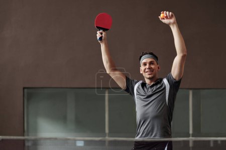 Foto de Feliz joven deportista emocionado celebrando juego ganador de tenis de mesa - Imagen libre de derechos