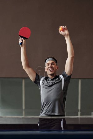 Téléchargez les photos : Portrait de heureux jeune joueur de tennis de table excité jeu gagnant - en image libre de droit