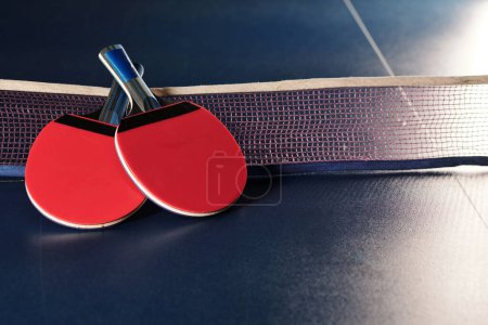 Téléchargez les photos : Deux raquettes et un filet sur la table de ping pong - en image libre de droit