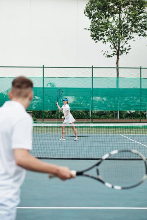 Photo for Young couple enjoying playing tennis on outdoor court - Royalty Free Image