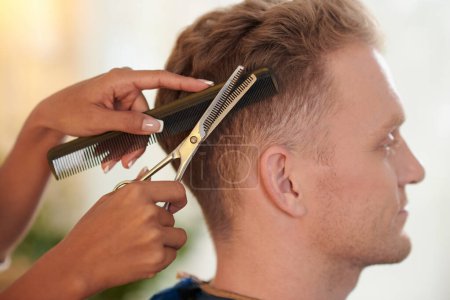 Photo for Close-up image of woman cutting hair of blond young man - Royalty Free Image