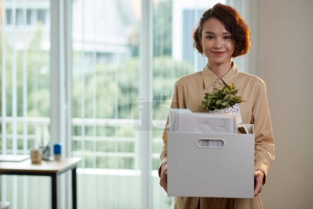Photo for Happy young company employee holding box with belongings - Royalty Free Image