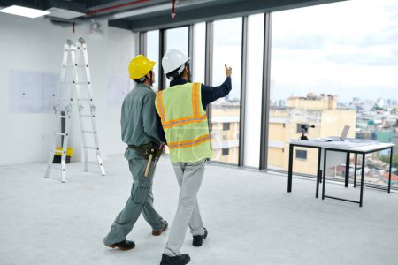 Photo for Engineer and contractor discussing how to build room divider - Royalty Free Image