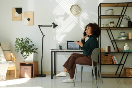 Foto de Mujer trabajando en su oficina en casa, llamando al equipo de plomo para discutir la implementación de código - Imagen libre de derechos