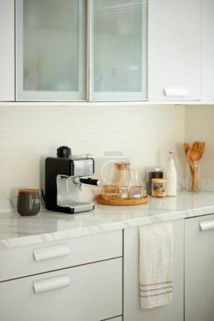 Foto de Máquina de café, frascos y tazas en el mostrador de cocina - Imagen libre de derechos