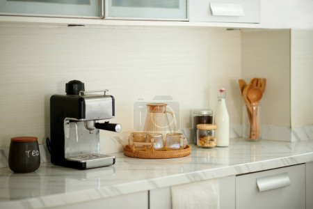 Téléchargez les photos : Station de café à la maison avec pot d'eau, bouteille de lait et machine à café - en image libre de droit