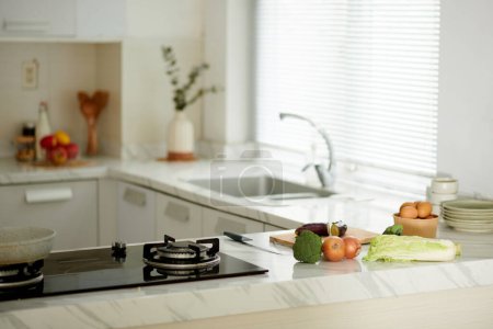 Téléchargez les photos : Légumes frais sur le comptoir de cuisine à côté de la cuisinière - en image libre de droit
