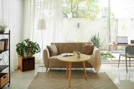 Téléchargez les photos : Petite table basse en bois à côté du canapé confortable dans le salon - en image libre de droit