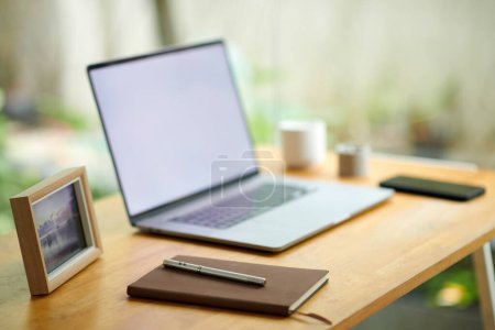 Photo for Planner and pen next to laptop on home office desk in room with huge windows - Royalty Free Image