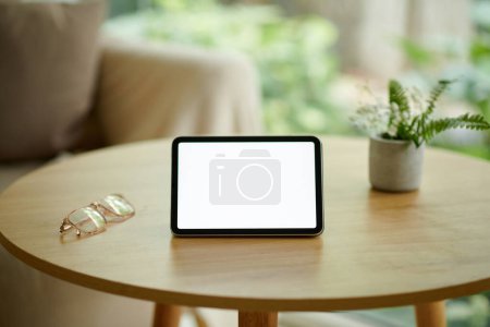 Téléchargez les photos : Tablette avec écran vide sur la table basse à côté des verres - en image libre de droit