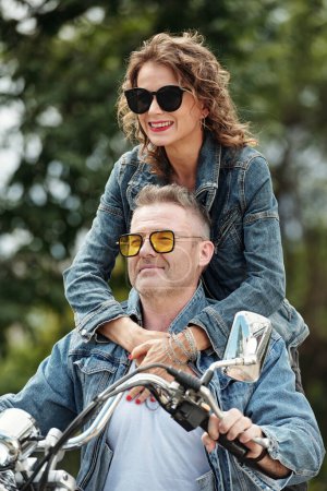 Téléchargez les photos : Couple d'âge mûr progressif ayant une retraite active, ils roulent à moto en ville - en image libre de droit